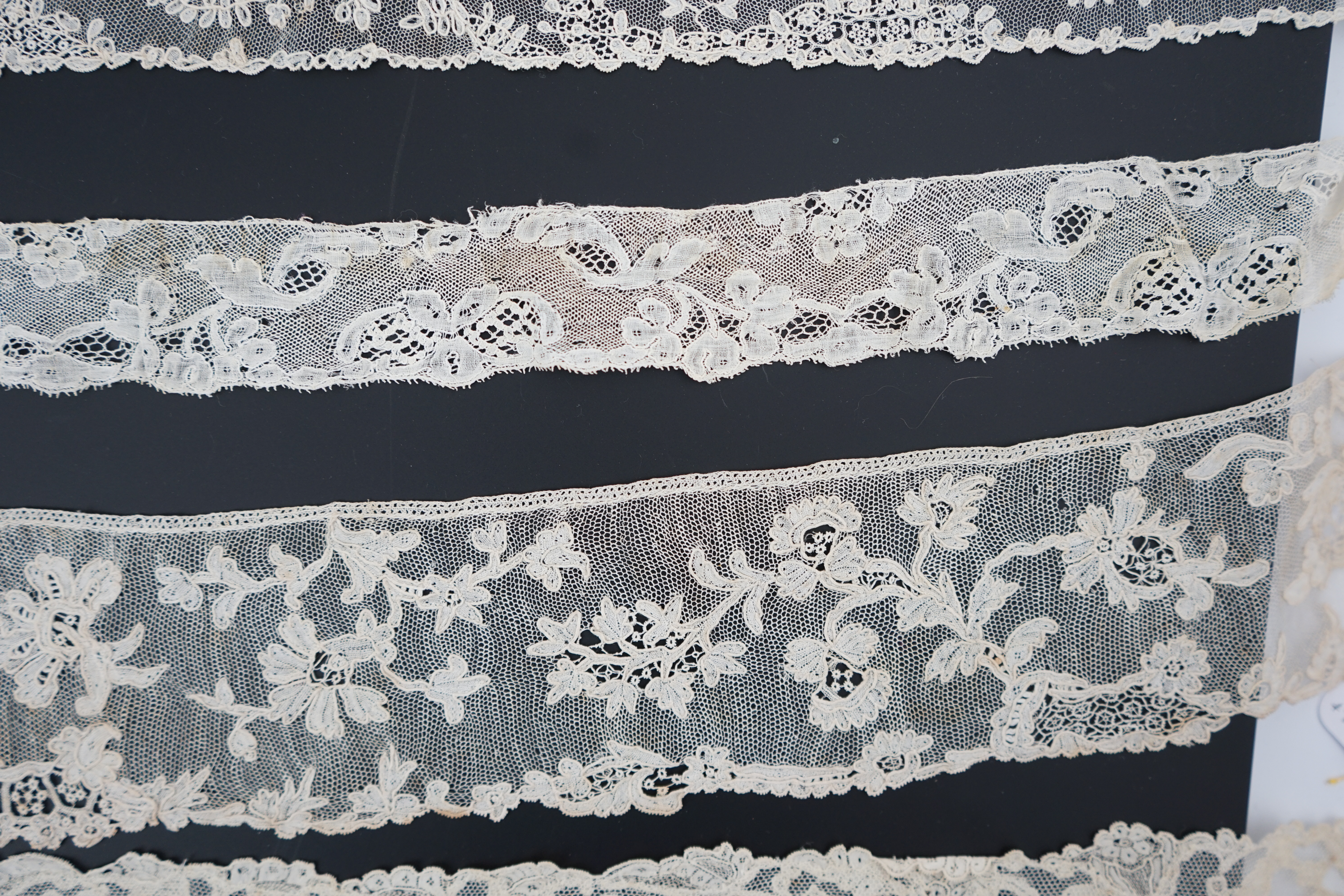 A large section of an ornate 19th century Brussels bobbin lace wedding veil, with two finished edges and one cut edge together with 18th century and later needle lace, an Argentan and an Alencon trimming, possibly an 18t